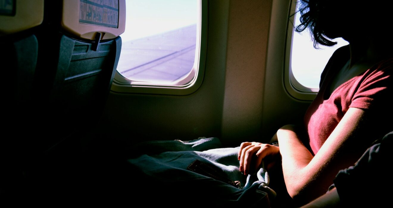 woman riding in airplane while watching at window