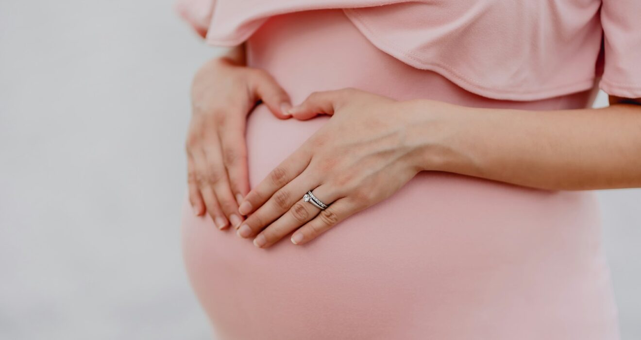 woman wearing gold ring and pink dress